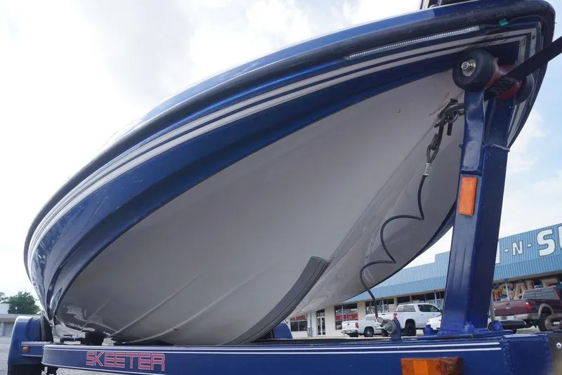 Slide: The Image of 2007 Skeeter SL 210 boat on trailer, showcasing sleek blue hull design. - 11