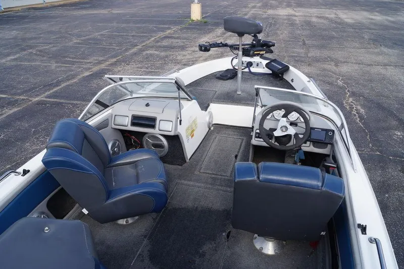 Slide: The Image of 2007 Skeeter SL 210 boat interior with blue seats and steering console. - 13