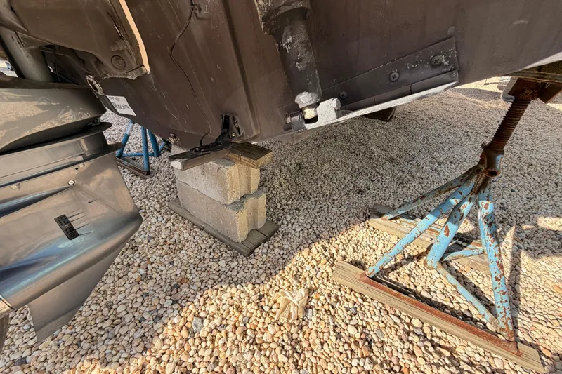 Slide: The Image of 2020 Scout 195 Sportfish boat supported by cinder blocks and stands on gravel. - 17