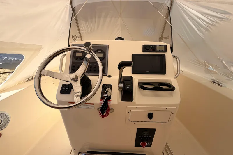 Slide: The Image of 2020 Scout 195 Sportfish boat helm with steering wheel and navigation controls. - 5