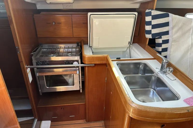 Slide: The Image of Galley kitchen in 2002 Beneteau First 36.7 yacht with stove, sink, and storage. - 6