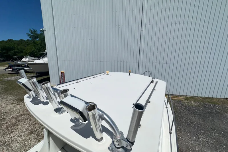 Slide: The Image of 2009 Steiger Craft 255 Miami boat with rod holders, parked near a large building. - 16