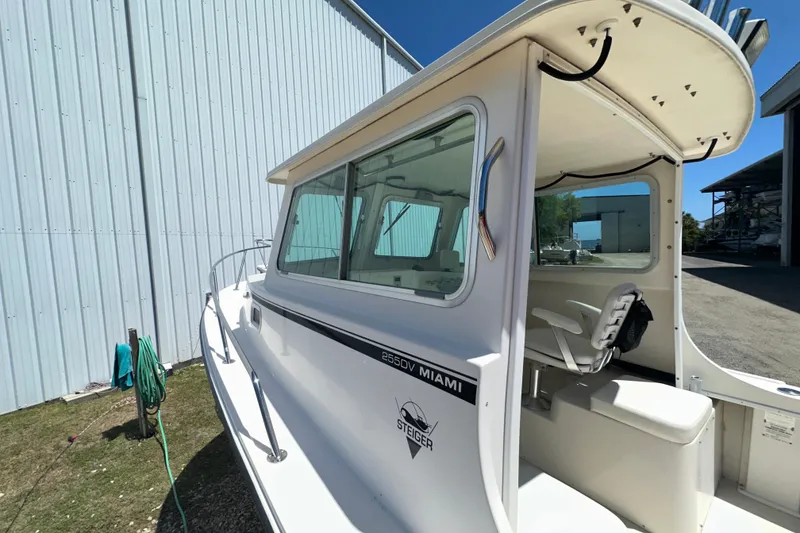 Slide: The Image of 2009 Steiger Craft 255 Miami boat docked beside a metal building. - 18