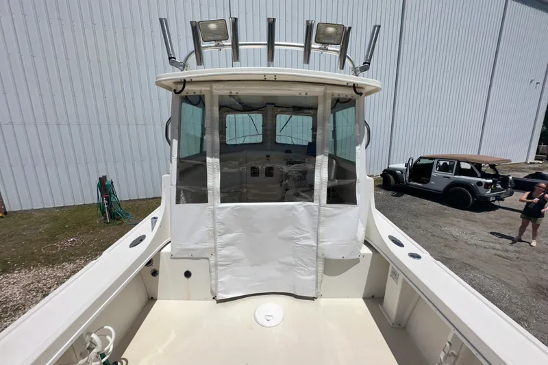 Slide: The Image of 2009 Steiger Craft 255 Miami boat with enclosed cabin, docked near a warehouse. - 20