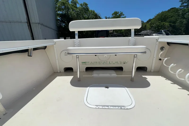 Slide: The Image of 2009 Steiger Craft 255 Miami boat deck with seating and storage, under clear blue sky. - 25
