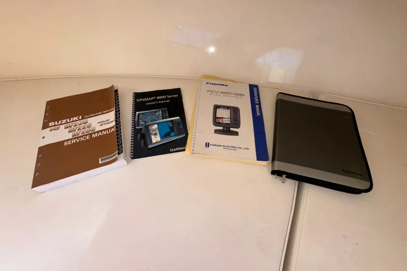 Slide: The Image of Manuals for Suzuki outboard motor, Garmin GPSMAP 4000, and Furuno echo sounder on a Steiger Craft 255 Miami. - 60