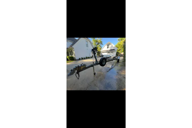 Slide: The Image of 2009 Steiger Craft 255 Miami boat trailer parked in a residential driveway. - 61