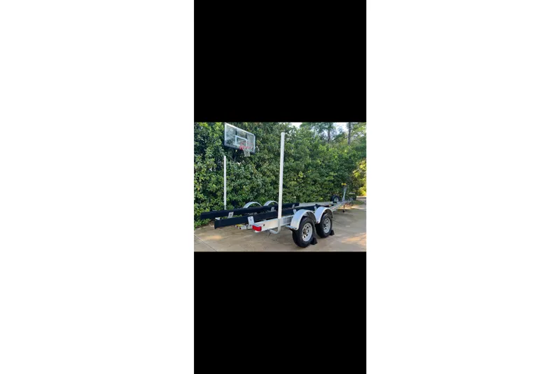 Slide: The Image of Trailer for 2009 Steiger Craft 255 Miami boat, parked near basketball hoop. - 63