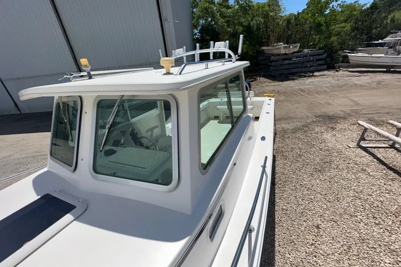 Slide: The Image of 2009 Steiger Craft 255 Miami boat docked outdoors, showcasing cabin and deck. - 7