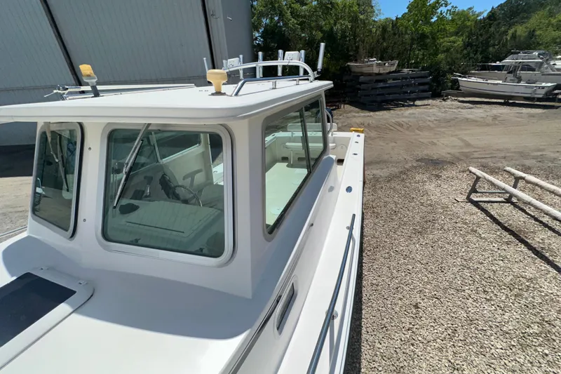 Slide: The Image of 2009 Steiger Craft 255 Miami boat parked on gravel near a warehouse. - 9