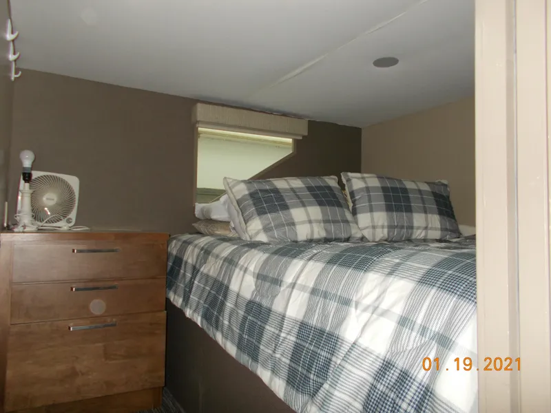 Slide: The Image of Cozy RV bedroom with plaid bedding and wooden dresser. - 14