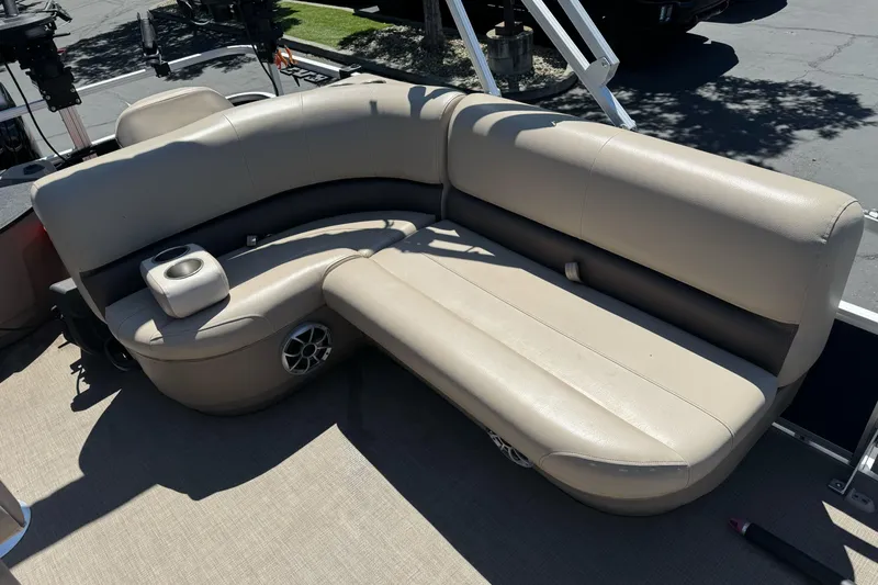 Slide: The Image of 2025 Sun Tracker Bass Buggy 18 DLX pontoon boat with beige seating and cup holders. - 16