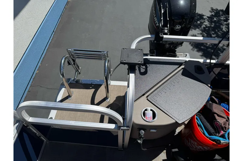 Slide: The Image of 2025 Sun Tracker Bass Buggy 18 DLX boat deck with motor and storage area. - 22