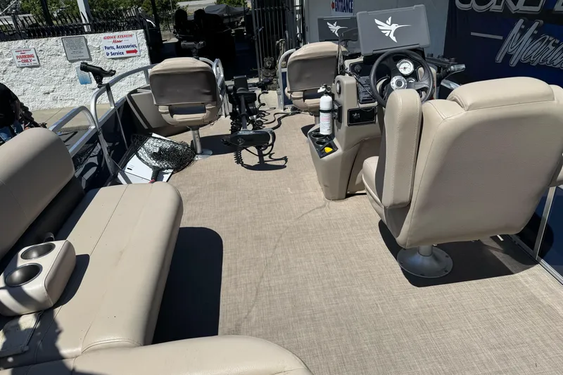 Slide: The Image of 2025 Sun Tracker Bass Buggy 18 DLX interior with beige seating and steering console. - 27