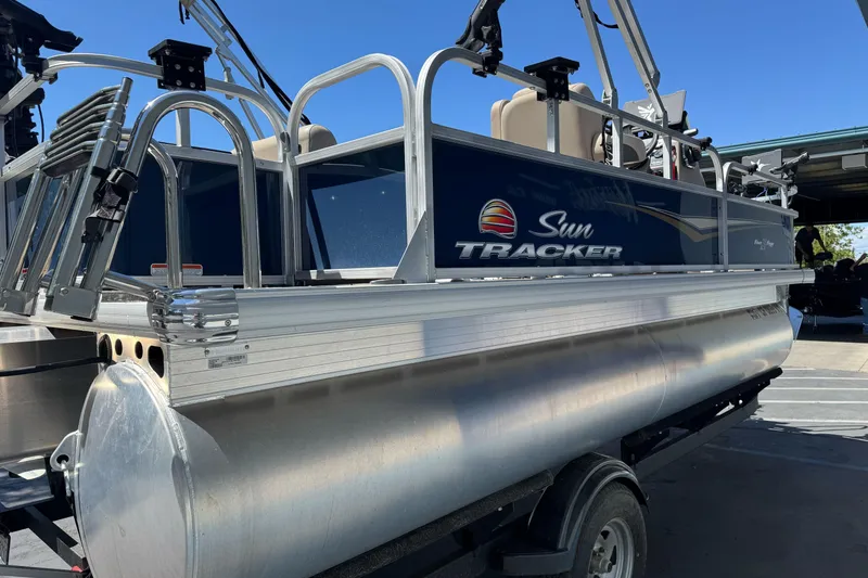 Slide: The Image of 2025 Sun Tracker Bass Buggy 18 DLX pontoon boat in a marina setting. - 5