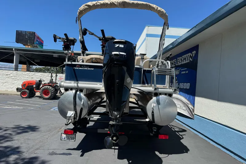Slide: The Image of 2025 Sun Tracker Bass Buggy 18 DLX pontoon boat with Mercury 75 engine in parking lot. - 6