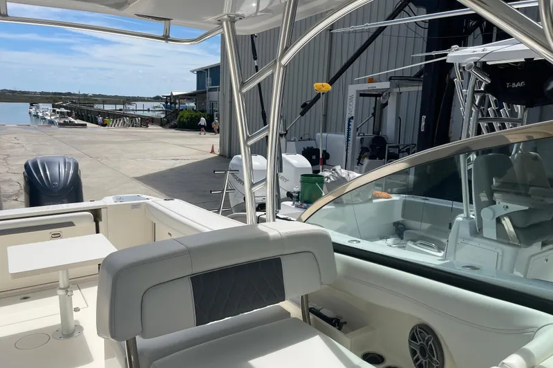 Slide: The Image of 2023 Cobia 280 Dual Console boat docked at marina with scenic waterfront view. - 15