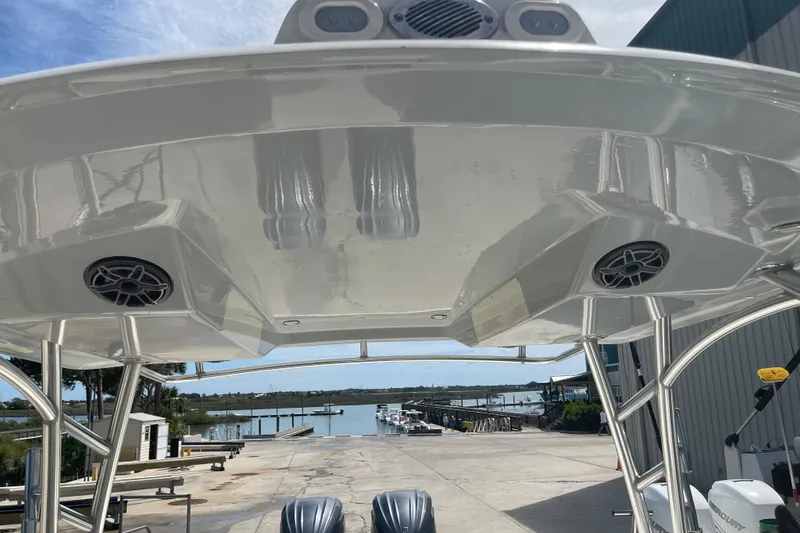 Slide: The Image of 2023 Cobia 280 Dual Console boat with speakers, docked at a marina. - 16