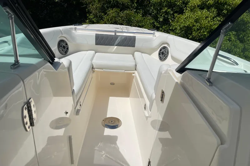 Slide: The Image of 2023 Cobia 280 Dual Console boat interior with white seating and speakers. - 20