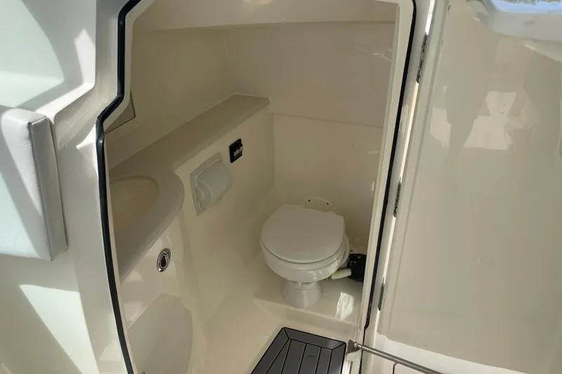 Slide: The Image of 2023 Cobia 280 Dual Console boat interior bathroom with toilet and sink. - 23