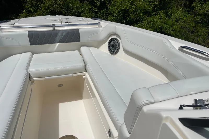 Slide: The Image of 2023 Cobia 280 Dual Console boat interior with white seating and speaker. - 25