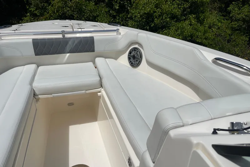 Slide: The Image of Luxurious seating area on 2023 Cobia 280 Dual Console boat, featuring white upholstery and speaker. - 26