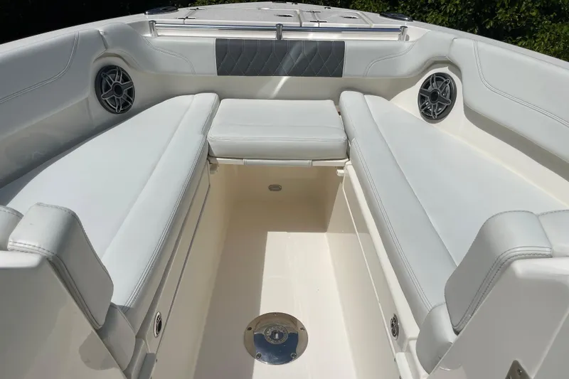 Slide: The Image of 2023 Cobia 280 Dual Console boat interior with white seating and speakers. - 27