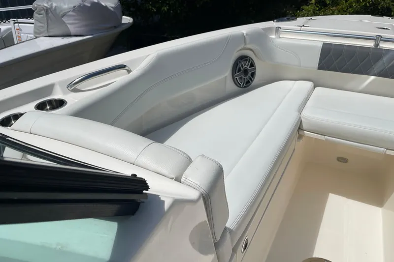 Slide: The Image of 2023 Cobia 280 Dual Console boat interior with white seating and cup holders. - 28