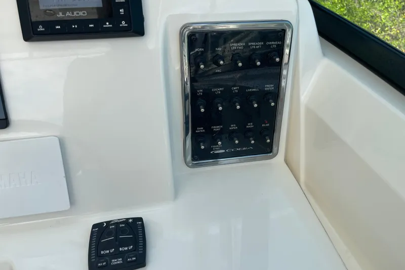 Slide: The Image of Control panel of 2023 Cobia 280 Dual Console boat with switches and audio system. - 37