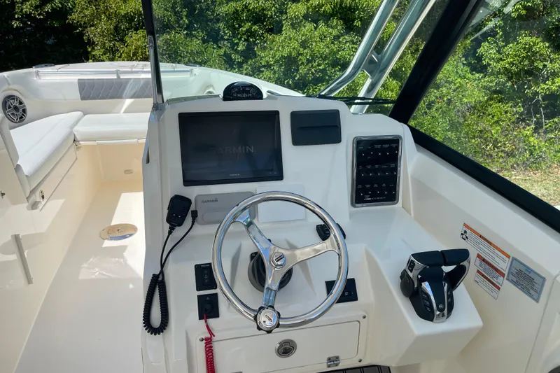 Slide: The Image of 2023 Cobia 280 Dual Console boat helm with Garmin display and steering wheel. - 40
