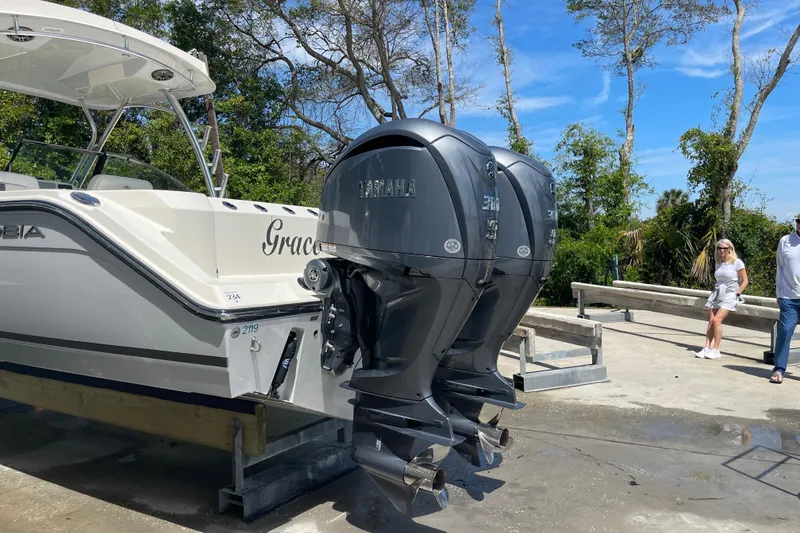 Slide: The Image of 2023 Cobia 280 Dual Console boat with twin Yamaha engines on a sunny day. - 51