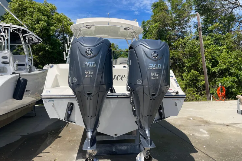 Slide: The Image of 2023 Cobia 280 Dual Console with twin Yamaha 300 V6 engines, docked outdoors. - 8