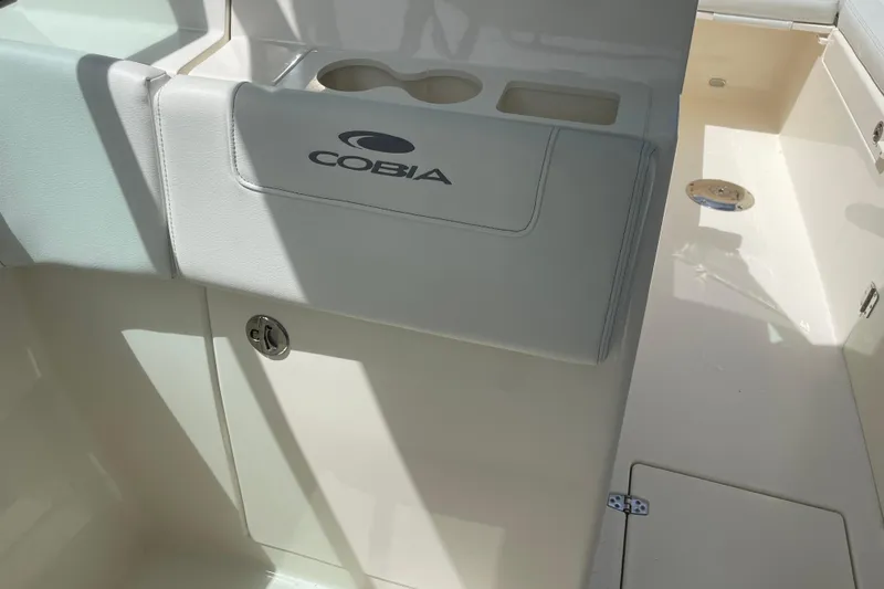Slide: The Image of 2023 Cobia 280 Dual Console boat interior with branded seating and cup holders. - 9