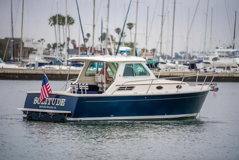 The Image of 2005 Back Cove Downeast Hardtop boat in marina, displaying American flag. - 0