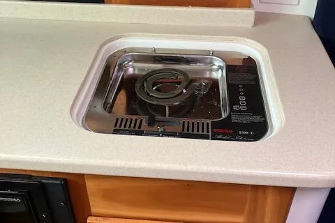 Slide: The Image of 2005 Back Cove Downeast Hardtop boat stove in compact kitchen setting. - 11