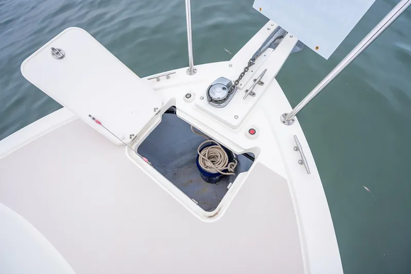 Slide: The Image of 2005 Back Cove Downeast Hardtop boat anchor locker with rope, open hatch, and calm water. - 26