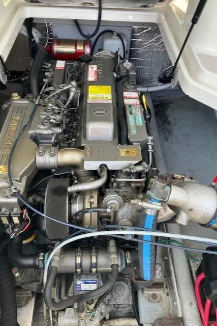 Slide: The Image of Engine compartment of a 2005 Back Cove Downeast Hardtop boat, showcasing detailed mechanical components. - 39
