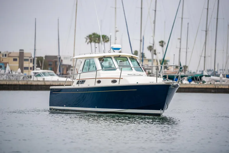 Slide: The Image of 2005 Back Cove Downeast Hardtop boat docked in marina, calm water, overcast sky. - 47