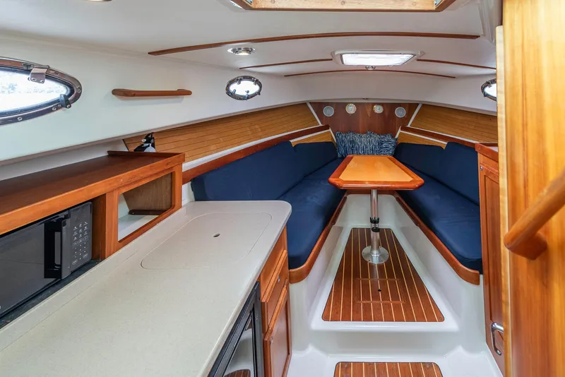 Slide: The Image of 2005 Back Cove Downeast Hardtop cabin interior with wood finish and blue seating. - 5