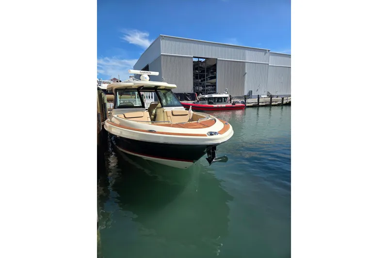 Slide: The Image of 2023 Chris-Craft Calypso 35 boat docked near a marina warehouse. - 11