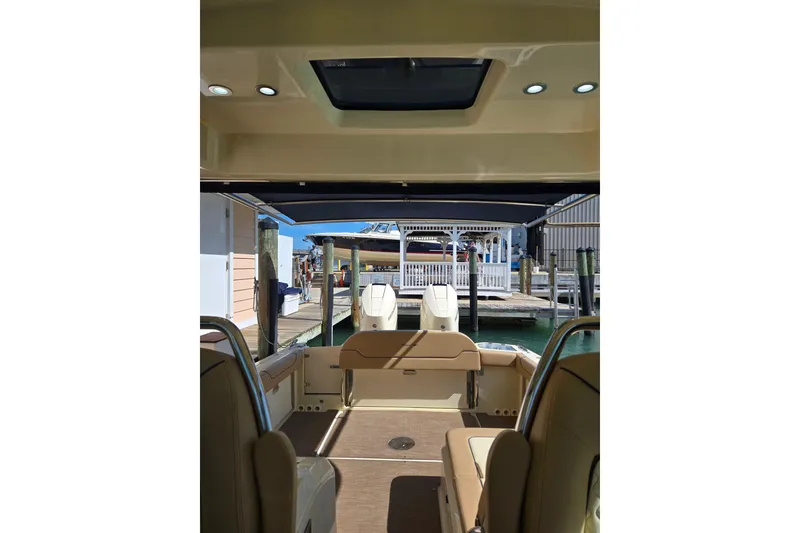 Slide: The Image of 2023 Chris-Craft Calypso 35 interior view at dock, showcasing seating and outboard motors. - 15