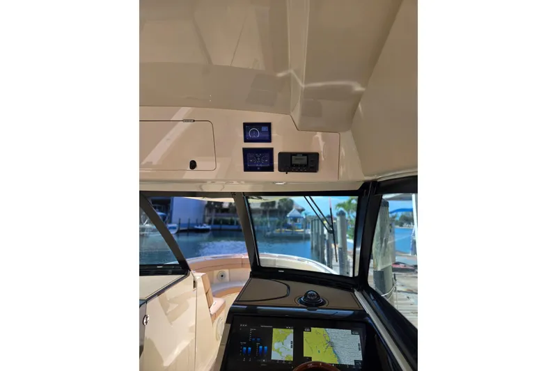 Slide: The Image of 2023 Chris-Craft Calypso 35 cockpit with navigation screens and waterfront view. - 17