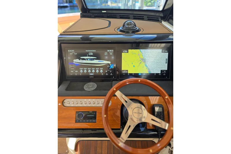 Slide: The Image of 2023 Chris-Craft Calypso 35 dashboard with navigation screens and wooden steering wheel. - 18