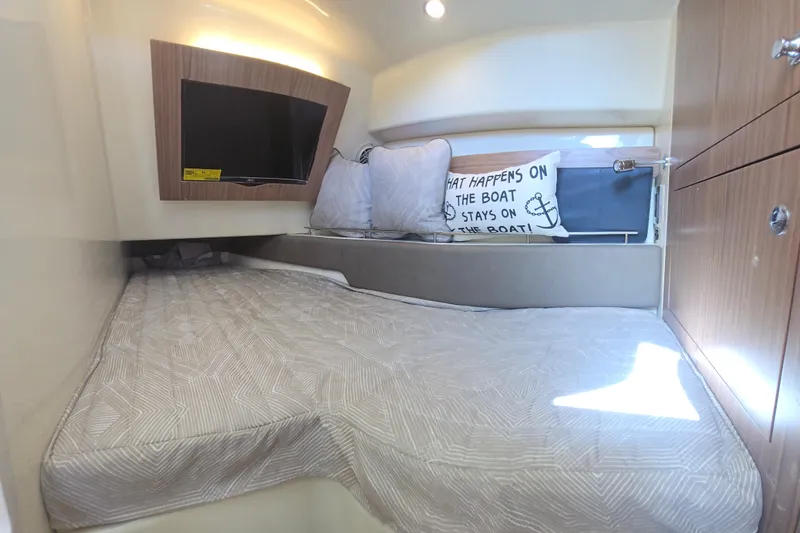 Slide: The Image of Cozy cabin interior of 2023 Chris-Craft Calypso 35 with bed, pillows, and TV. - 24
