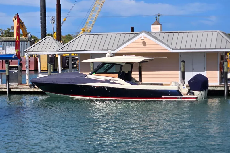 Slide: The Image of 2023 Chris-Craft Calypso 35 boat docked by a waterfront building under a clear blue sky. - 26