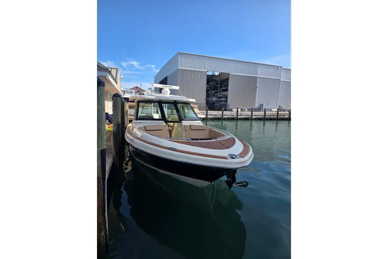 Slide: The Image of 2023 Chris-Craft Calypso 35 boat docked near a marina building. - 27
