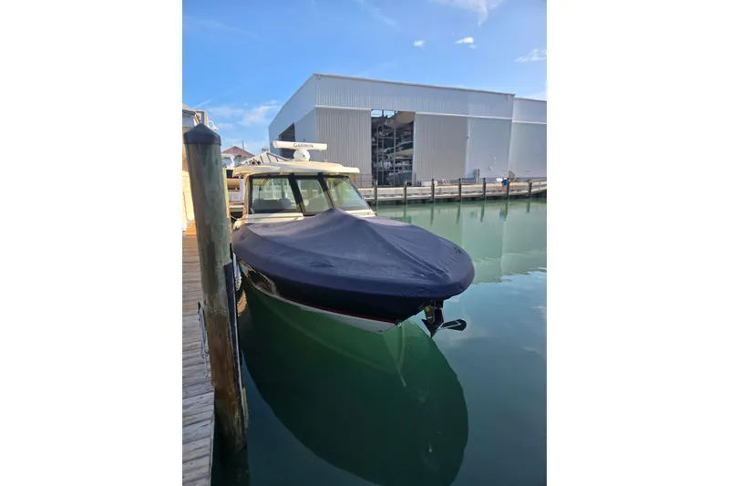 Slide: The Image of 2023 Chris-Craft Calypso 35 docked, covered, reflecting on calm water. - 29