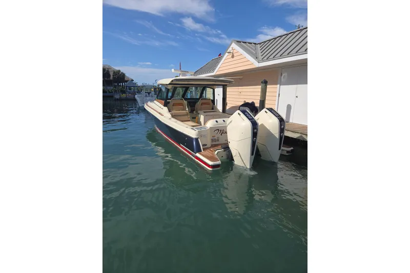 Slide: The Image of 2023 Chris-Craft Calypso 35 docked, featuring dual outboard engines and elegant design. - 3