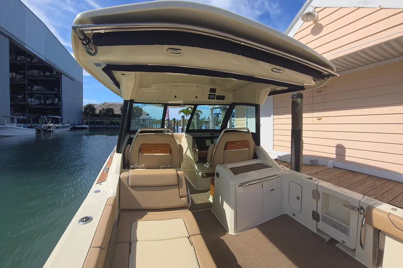 Slide: The Image of 2023 Chris-Craft Calypso 35 boat interior with luxurious seating and modern design at a marina. - 6