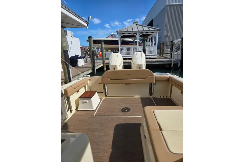 Slide: The Image of 2023 Chris-Craft Calypso 35 boat interior at dock, featuring seating and twin engines. - 7